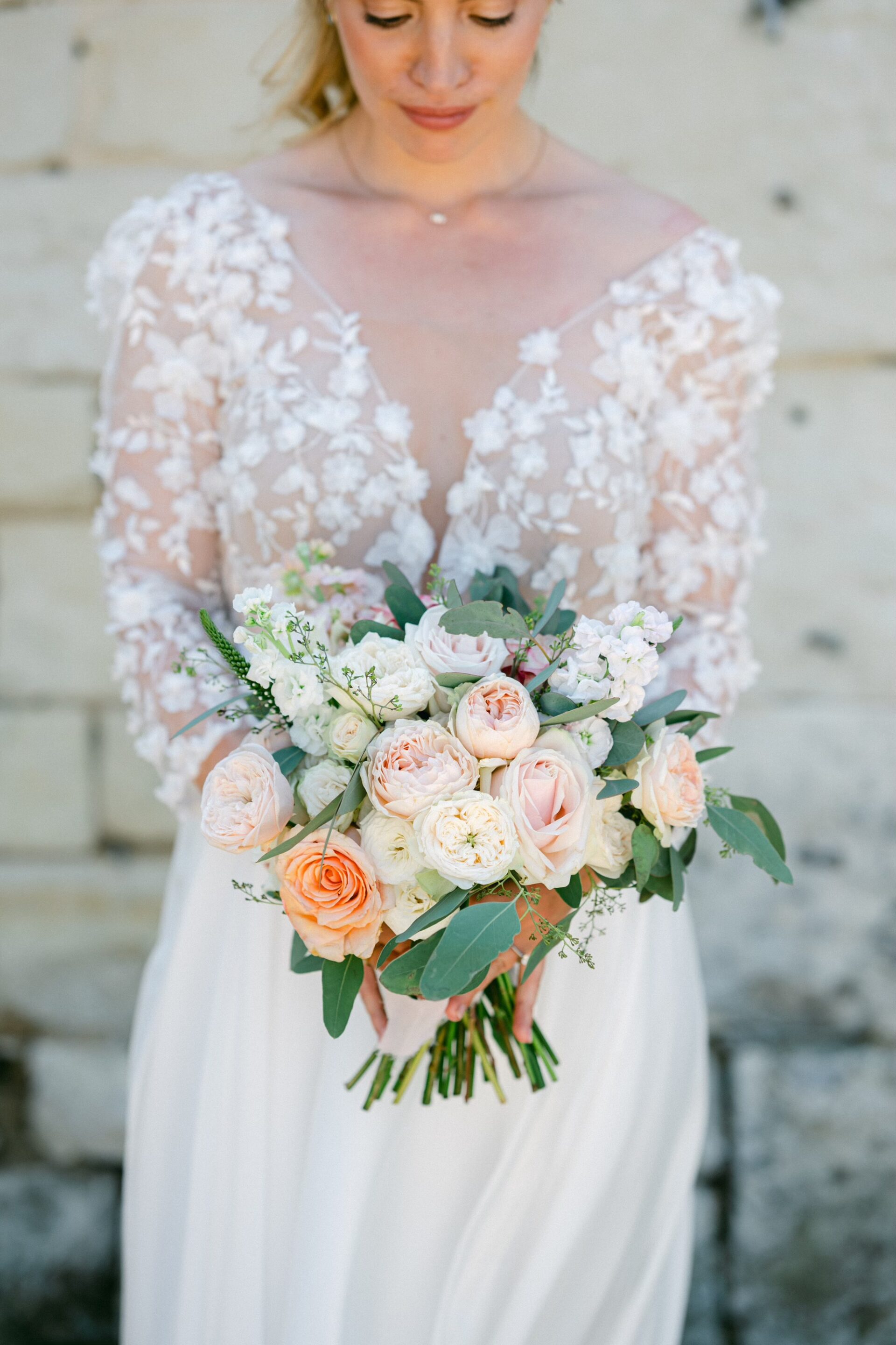 Mariée élégante portant une robe de mariée sur mesure en dentelle de Calais, création artisanale à Paris